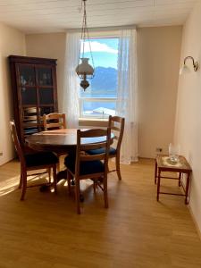 a dining room with a table and chairs and a window at Syðstibær Guesthouse in Hrísey