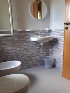 a bathroom with a sink and a toilet and a mirror at La Marina Bay in Vieste