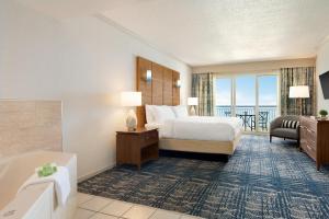um quarto de hotel com uma cama e uma banheira em Holiday Inn & Suites Ocean City, an IHG Hotel em Ocean City