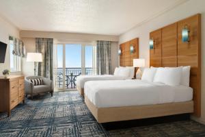 a hotel room with two beds and a balcony at Holiday Inn & Suites Ocean City by IHG in Ocean City