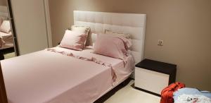 1 dormitorio con cama blanca y almohadas rosas en Apartment Da Rocha, en Portimão