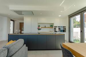 a kitchen with blue and white cabinets and a table at Chalet Mirador da Pinela in Cangas de Morrazo