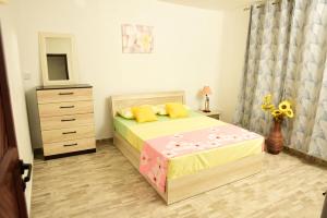 a bedroom with a bed with a dresser and a dresser at Casa Rosa in Flic-en-Flac