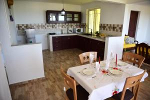 a kitchen with a table with a white table cloth at Casa Rosa in Flic-en-Flac +7 photos