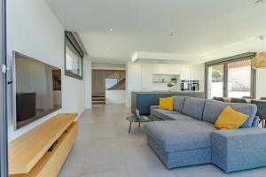 a living room with a blue couch and a flat screen tv at Chalet Mirador da Pinela in Cangas de Morrazo