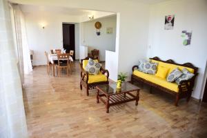 a living room with yellow couches and a table at Casa Rosa in Flic-en-Flac