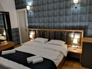 a bedroom with a large bed and two lamps on tables at 3 Rooms Hotel in Tbilisi City