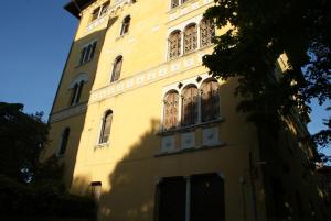 un edificio amarillo con ventanas laterales en Alla Residenza Domus Minervae, en Perugia