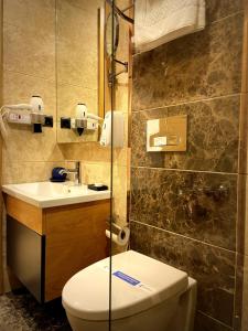 Inanlar Garden Hotel & Bungalow في أوزونغول: حمام مع مرحاض ومغسلة