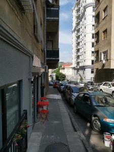 uma rua da cidade com carros estacionados e uma mesa vermelha em 3 Rooms Hotel em Tbilisi