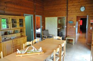 a dining room with a table and a kitchen at Gite L'unité in Hour +12 photos