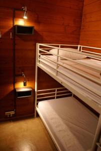 two bunk beds in a room with wooden walls at Gite L'unité in Hour