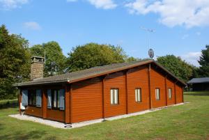 a small wooden cabin in a grassy field at Gite L'unité in Hour
