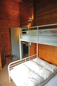 a bedroom with bunk beds in a wooden room at Gite L'unité in Hour