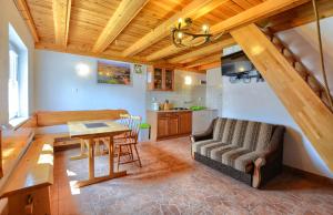 cocina y sala de estar con mesa y sofá en Domki nad Stebnikiem, en Ustrzyki Dolne