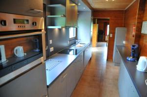 a kitchen with stainless steel appliances and a long counter at Gite L'unité in Hour