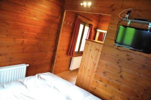 a bedroom with wooden walls and a tv on a wall at Gite L'unité in Hour