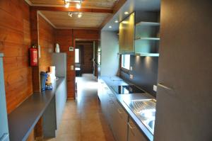 a kitchen with stainless steel appliances and wooden walls at Gite L'unité in Hour