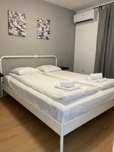 Una cama blanca con sábanas blancas y almohadas. en Villa Darina, en Portorož
