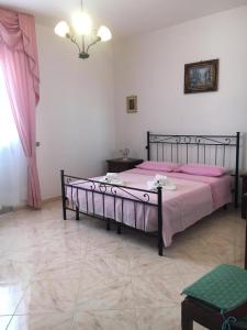 1 dormitorio con 1 cama grande con sábanas rosas en Appartamento Rocco, en Castro di Lecce