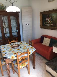 sala de estar con mesa y sofá rojo en Appartamento Rocco, en Castro di Lecce
