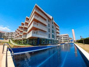 Solarium Residence no Porto das Dunas في فورتاليزا: مبنى فيه مسبح امام مبنى