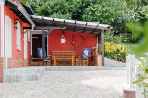 a wooden table and chairs in front of a red house at Landhaus in Remptendorf