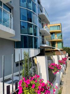 a building with pink flowers in front of it at Hotel ECO Palace in Primorsko