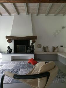 a living room with a chair and a fireplace at Villa Rustico in Viboldone