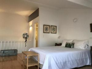 1 dormitorio con 1 cama blanca grande y ventilador en Alarco - 55753AL, en Lisboa