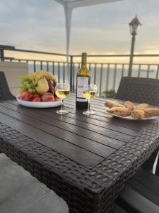 a table with two glasses of wine and a plate of food at Guest House ETM in Makhinjauri +52 photos