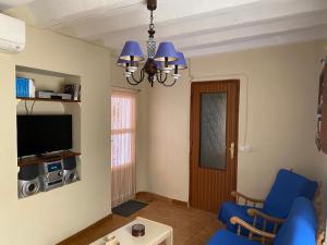 sala de estar con sofá azul y TV en Casa Monedero, en La Recueja
