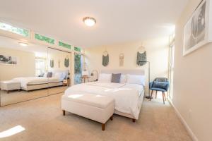 a bedroom with a large white bed and a mirror at Beach Resort Home with Ocean Views Jacuzzi & Sauna! in San Diego