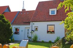 une maison blanche avec un toit rouge dans l'établissement Dein Ferienhaus in Wernigerode, à Wernigerode