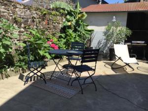 una mesa y sillas en un patio en Les2 cerisiers en Pontorson