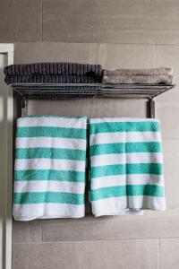zwei Handtücher auf einem Handtuchhalter im Bad in der Unterkunft The Palm Leaf Apartments in Noord