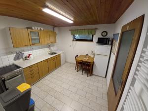 uma cozinha com uma mesa e um frigorífico branco em Apartmány Lebedín em Nová Ves