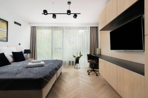 a bedroom with a bed and a flat screen tv at EASY RENT Apartments - GOLD 36, Basen & SPA, Centrum Free Parking 24h Check-in in Lublin