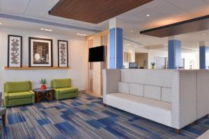 an office lobby with two chairs and a reception desk at Holiday Inn Express & Suites - Wildwood - The Villages, an IHG Hotel in Wildwood