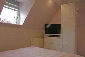- une chambre avec un lit, une télévision et une fenêtre dans l'établissement Dein Ferienhaus in Wernigerode, à Wernigerode