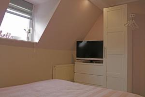 a bedroom with a bed and a tv and a window at Dein Ferienhaus in Wernigerode in Wernigerode