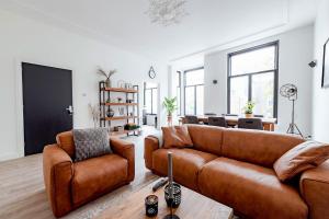 a living room with two leather couches and a tv at LVM Stays in The Hague