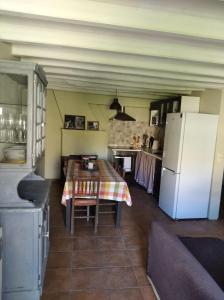 a kitchen with a table and a white refrigerator at Ca La Marutxi in Cantallops