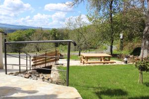 a picnic table and a bench in a park at A Nosa Casa 2 in Belesar
