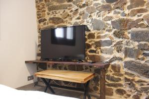 a flat screen tv sitting on a stone wall at A Nosa Casa 2 in Belesar