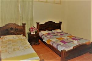 1 dormitorio con 2 camas y una mesa con flores en HOTEL TAYRONA IMPERIAL en Bucaramanga