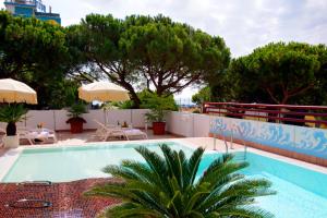 une piscine sur le toit d'un immeuble avec des arbres dans l'établissement Hotel Coppe Jesolo, à Lido di Jesolo