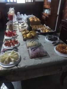 una mesa larga con un montón de comida. en Francis Hotel Pousada en Caraguatatuba