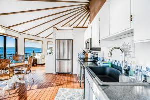 a kitchen with white cabinets and a dining room with a table at The Angle Inn in Hoodsport