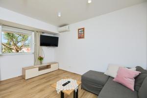 uma sala de estar com um sofá e uma televisão em Guest House Anica em Dubrovnik